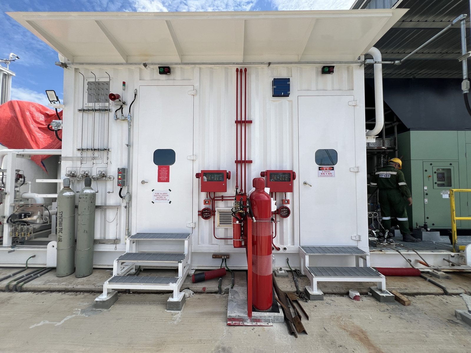 Wide view of fire suppression equipment, pipework, control panels, and cylinders